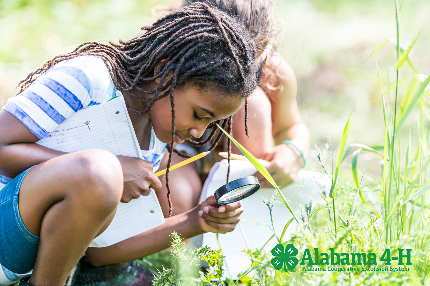 Alabama 4-H Project WILD 4-H member looking through magnifying glass