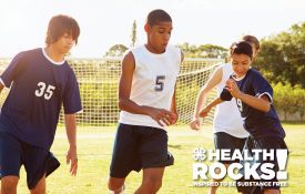 Four ethnically diverse middle school children playing team soccer