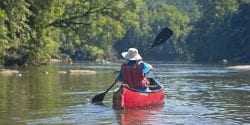 A person canoeing on a river.