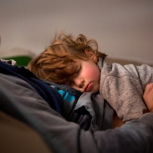 Toddler having a nap with dad in the sofa