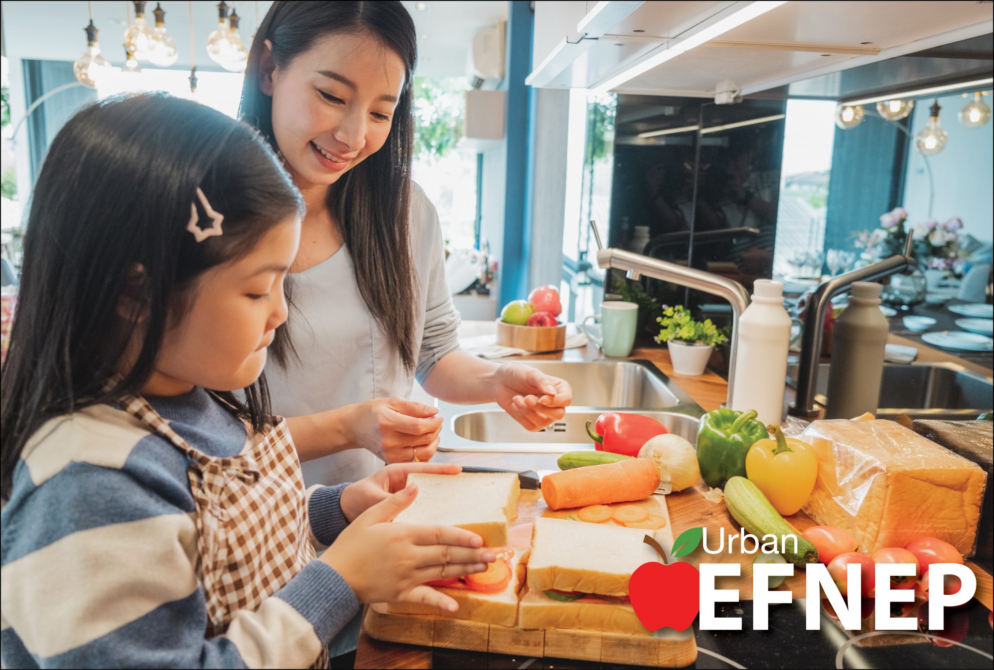 Asian mother and daughter make healthy vegetable sandwiches together in their kitchen