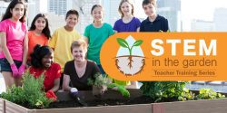 A teacher kneels beside a raised bed garden with seven middle school students.