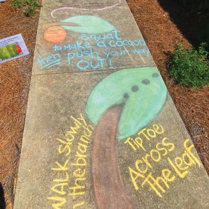 A physical activity game and art written in chalk on a sidewalk.