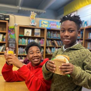 Two young, Black, male students in a library
