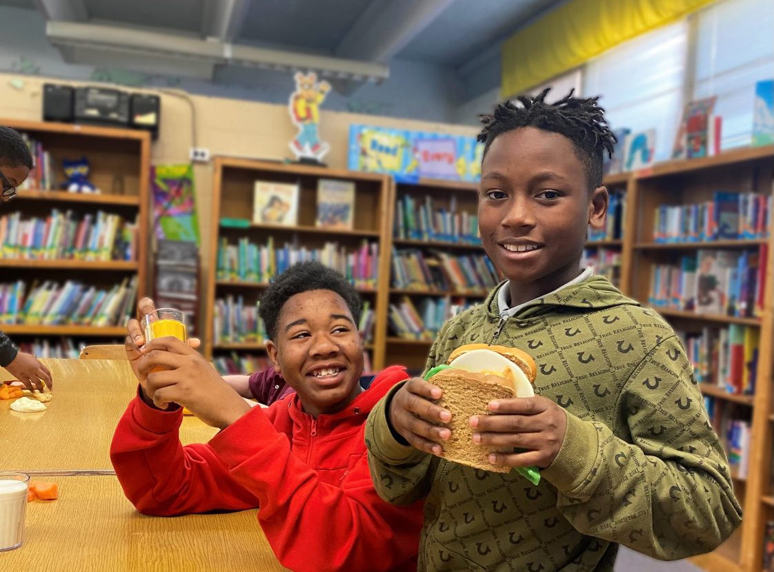 Two young, Black, male students in a library