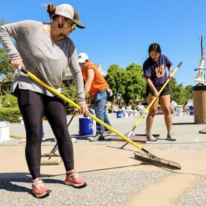 two women painting roundabout for Thriving Communities