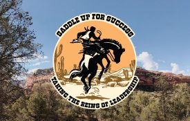 A desert scene with a logo of a cowboy on a horse with the following words: Saddle Up for Success. Taking the Reins of Leadership.