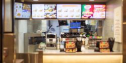A blurred image of a fast-food restaurant counter and menu board.