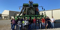 A group of people touring a cotton gin in Limestone County.