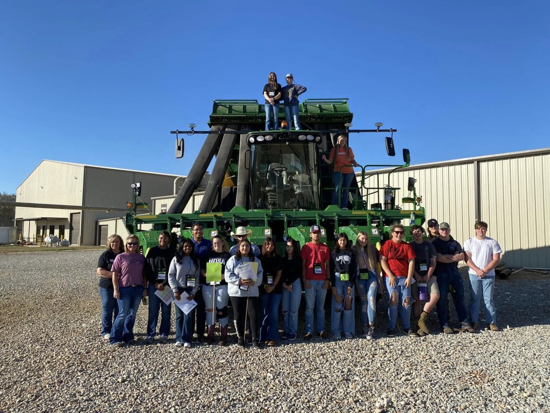 A group of people touring a cotton gin in Limestone County.