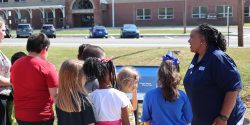 Kids reading the first page of the book on a book walk.