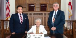 Majeed Dweik, Governor Kay Ivey, and Mike Phillips pose for a proclamation signing.