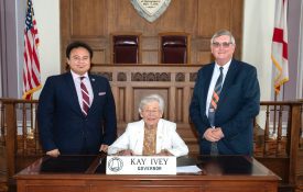 Majeed Dweik, Governor Kay Ivey, and Mike Phillips pose for a proclamation signing.