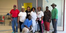 A group of people standing in front of the Boligee OnMed Care Station.