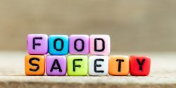 Colorful bead with black letter in word food safety on wood background