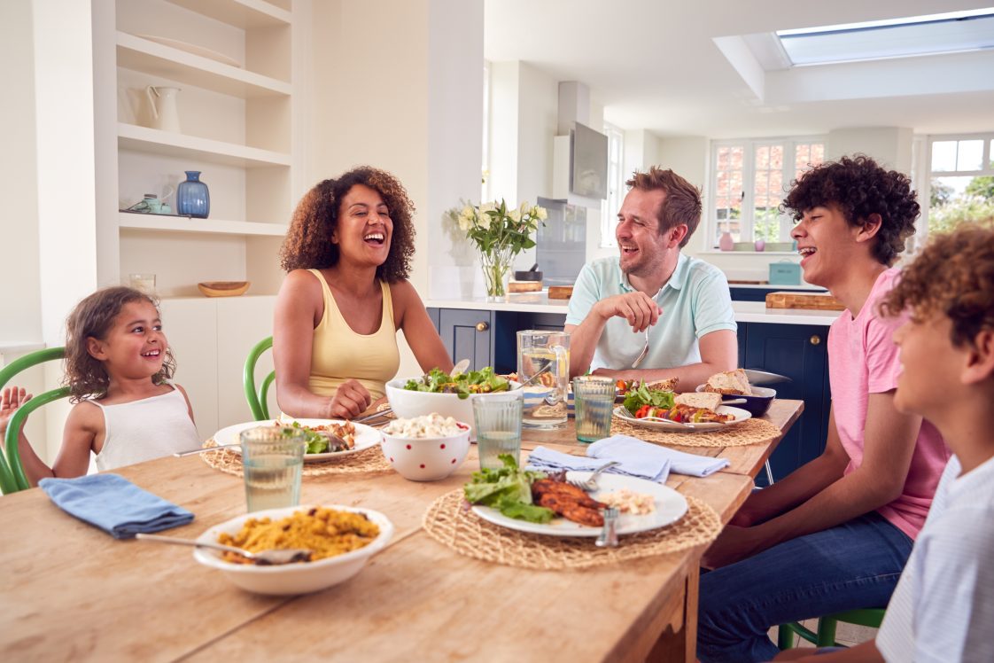 A family sitting around the table talking and laughing.