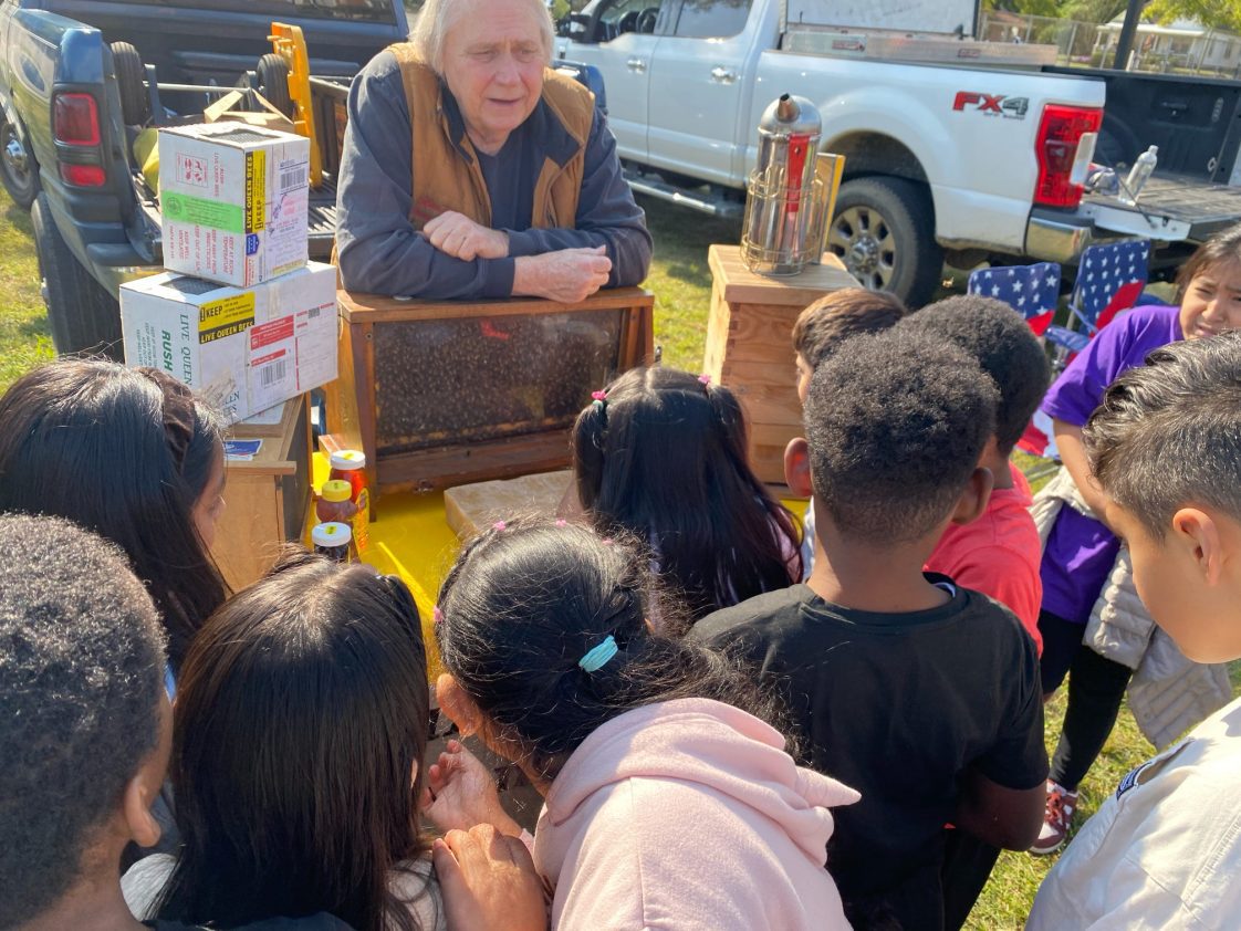 A beekeeper talking to kids about bees.