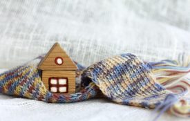 A small wooden house surrounded by a scarf.