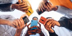 teens standing in a circle using cell phones